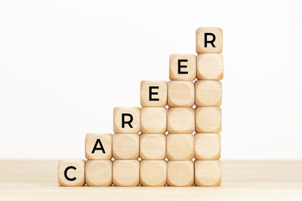 A staircase of wooden cubes forming the word “career” visually represents career growth.