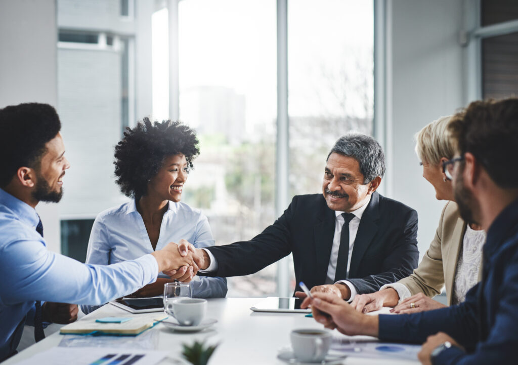 A sales professional shaking hands with the client while building rapport in sales.